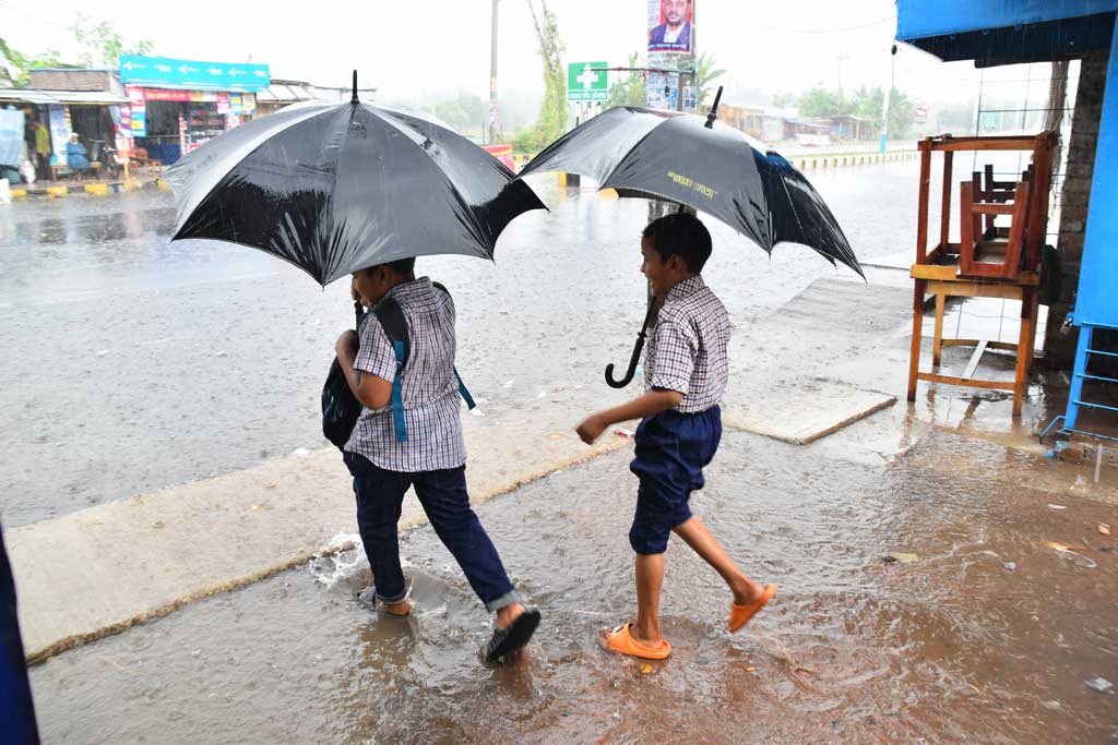 রাজশাহী নগরীতে সকালে নামে স্বস্তির বৃষ্টি। ছাতা নিয়ে দুই শিশুকে বিদ্যালয়ে যেতে দেখা যাচ্ছে। নগরীর মেহেরচন্ডী করইতলা এলাকা থেকে তোলা, রাজশাহী, ২০ মে ২০২৪। ছবি: মিলন শেখ