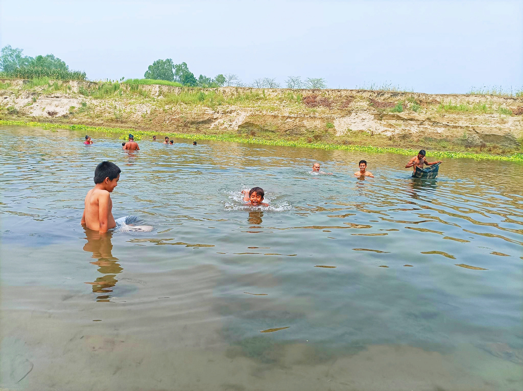 তীব্র গরমে হাপিত্যেশ মানুষসহ প্রাণিকুলের। গ্রীষ্মের তপ্ত দুপুরে একটুখানি স্বস্তি পেতে নদীতে গোসল করছে মানুষ ও গবাদিপশু। একদল শিশুও উচ্ছাসের সঙ্গে ছুটছে নদীতে গোসল করতে। কালীগঙ্গা নদী, সাইংজুরী এলাকা, ঘিওর উপজেলা, মানিকগঞ্জ, ১৯ এপ্রিল, ২০২৪। ছবি: আব্দুর রাজ্জাক 