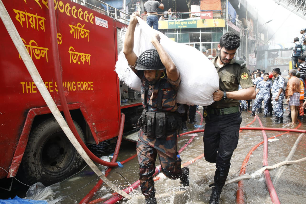 বিজিবি ও আনসার সদস্য মিলে ব্যবসায়ীদের মালামাল নিরাপদ স্থানে সরিয়ে নিচ্ছেন
