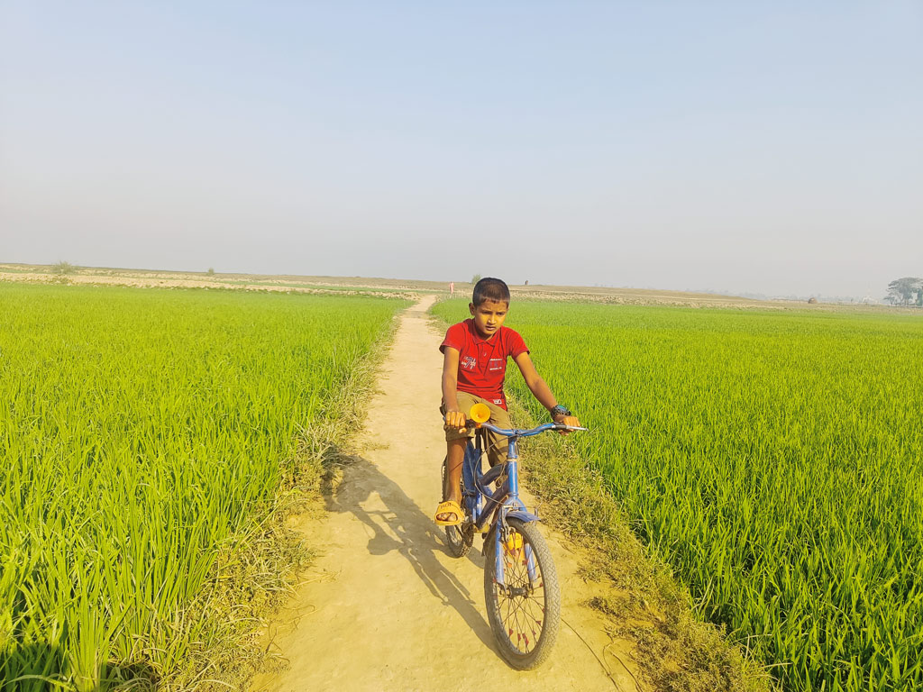 গ্রামের মেঠো পথে সাইকেল চালাচ্ছে এক কিশোর। সরাইল, ব্রাহ্মণবাড়িয়া, ১৪ ফেব্রুয়ারি, ২০২৩। ছবি: মো. মনসুর আলী