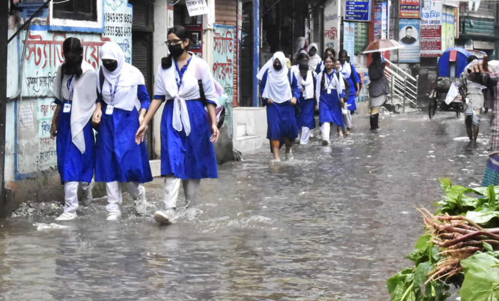 রাজধানীতে সারা রাতের বৃষ্টিতে সড়কসহ অলি-গলিতে জমেছে পানি। জলাবদ্ধতার কারণে স্কুলগামী শিক্ষার্থীরা পড়েছে দুর্ভোগে। কদমতলী একে স্কুল এন্ড কলেজের সামনে। ছবি: মেহেদী হাসান