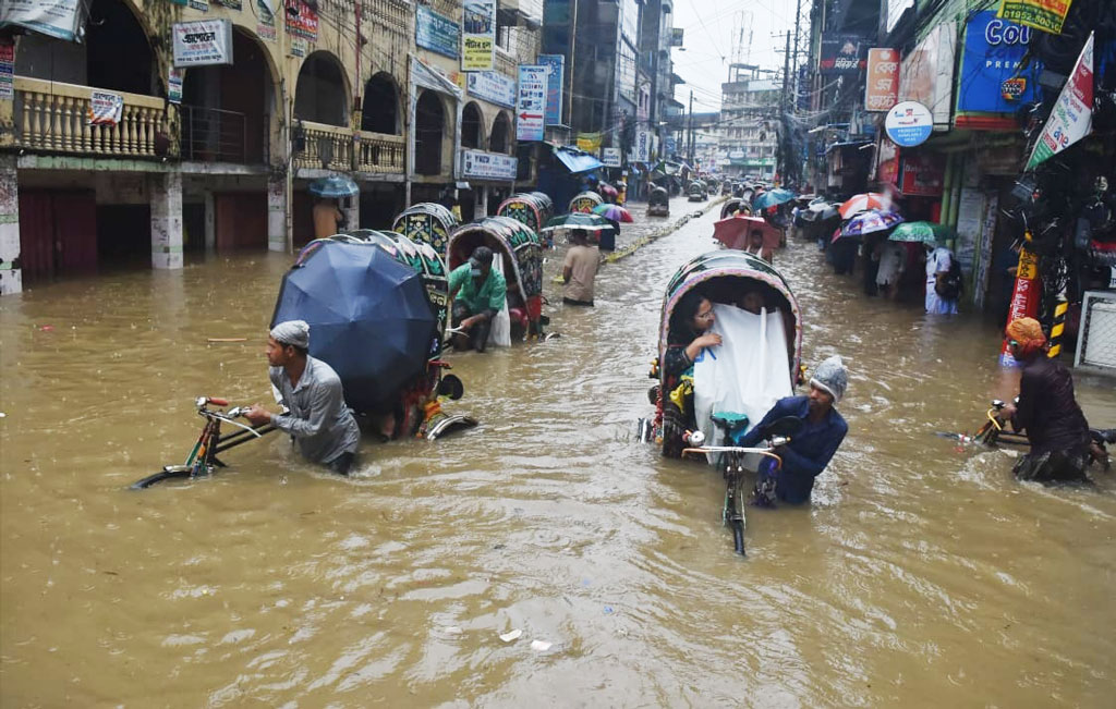 কয়েক দিনের টানা বৃষ্টি ও জোয়ারের কারণে কোমর সমান পানিতে যাতায়াত করতে হচ্ছে নগরবাসীকে। আজ চট্টগ্রাম নগরীর চকবাজার কাঁচা বাজার মোড় এলাকায়। ছবি: হেলাল সিকদার