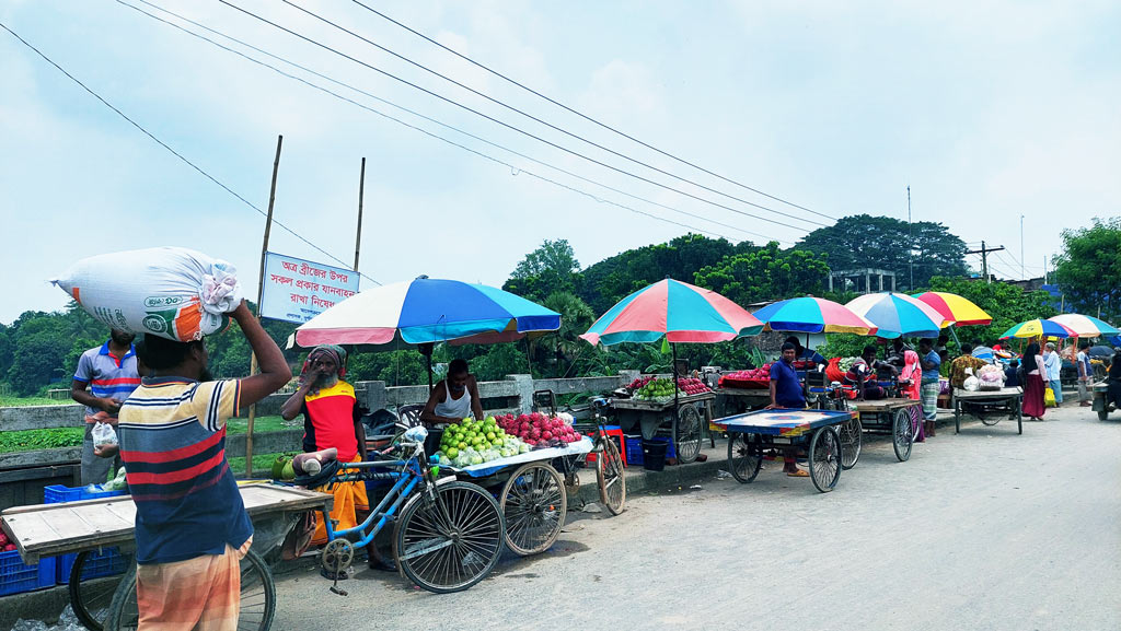 তিন চাকার ভ্যানে সেতু দখল হওয়ায় চলাচলের রাস্তা সরু হয়েছে। এতে উপজেলা মোড় থেকে জিয়া চত্বর মোড় পর্যন্ত তীব্র যানজটের সৃষ্টি হয়। সবচেয়ে বেশি বিপাকে পড়েন সেখান দিয়ে প্রতিনিয়ত চলাচলকারীরা। ছবি: আজকের পত্রিকা