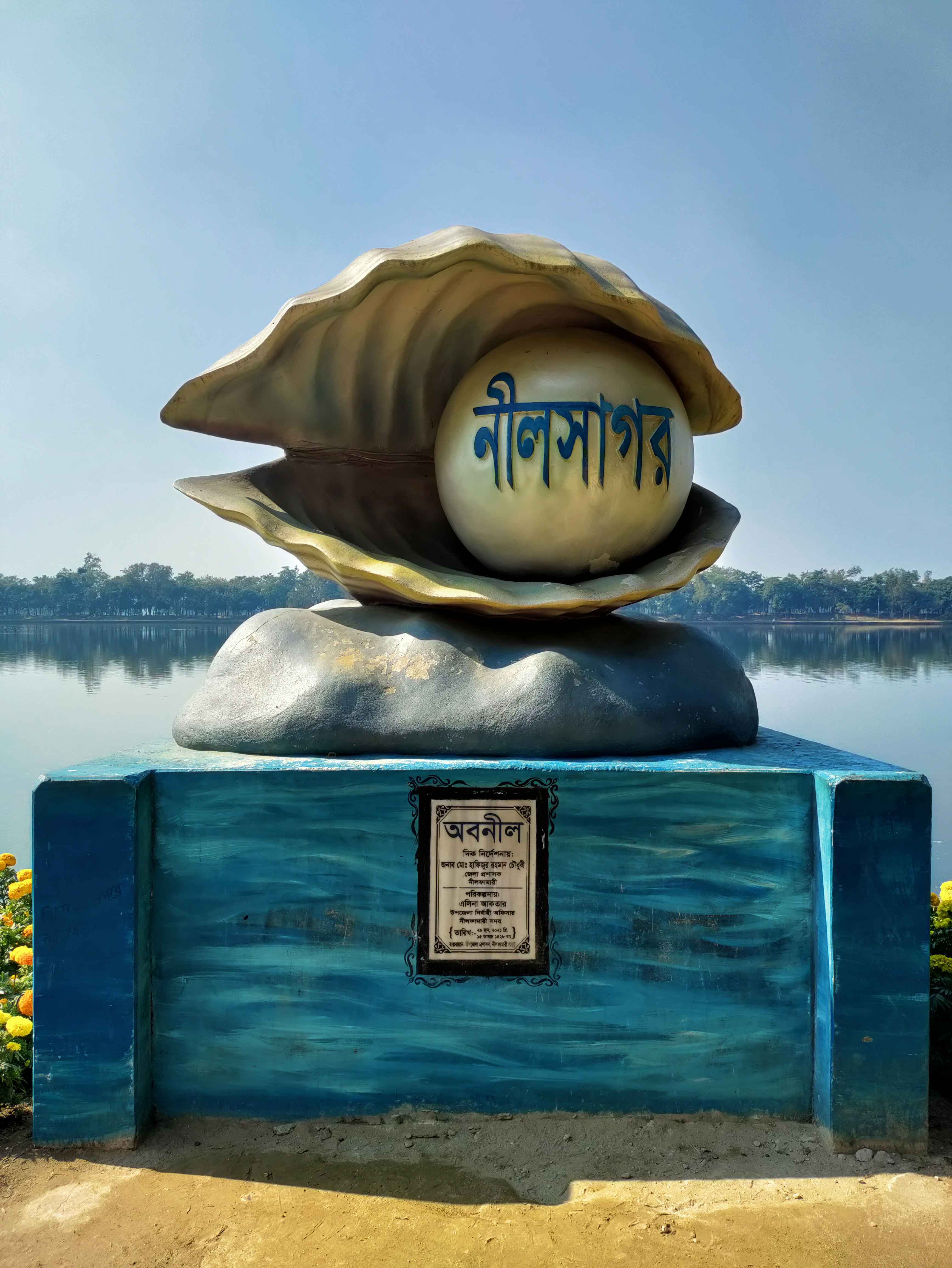 নীলফামারীর নীলসাগর স্তম্ভ। এর পেছনে প্রায় ৩৩ একর আয়তনের দিঘি দেখা যাচ্ছে। ছবি: লেখক