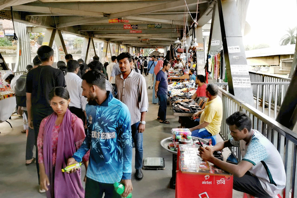 ঢাকার ফার্মগেটে পথচারীদের নিরাপদ পারাপারের জন্য নির্মাণ করা ফুটওভার ব্রিজটি এখন হকারদের দখলে। ব্রিজের দুই পাশে সারি সারি দোকান। এমনকি সিঁড়ির মুখেও চলে হকারদের বেচাকেনা। চলার পথ ছোট হওয়ায় পথচারীদের ভোগান্তিতে পড়তে হচ্ছে। ছবি: ওমর ফারুক
