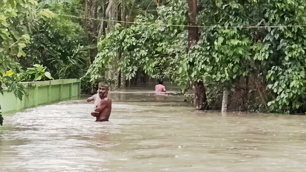 ঘূর্ণিঝড় রিমালের প্রভাবে জোয়ারের পানি প্রবেশ করেছে উপকূলবর্তী গ্রামে। তলিয়ে গেছে রাস্তা। কোমর সমান পানি দিয়ে আশ্রয়কেন্দ্রে যাচ্ছেন মানুষ। চরমানিকা ইউনিয়ন, চরফ্যাশন, ভোলা, ২৫ মে ২০২৪। ছবি: আজকের পত্রিকা