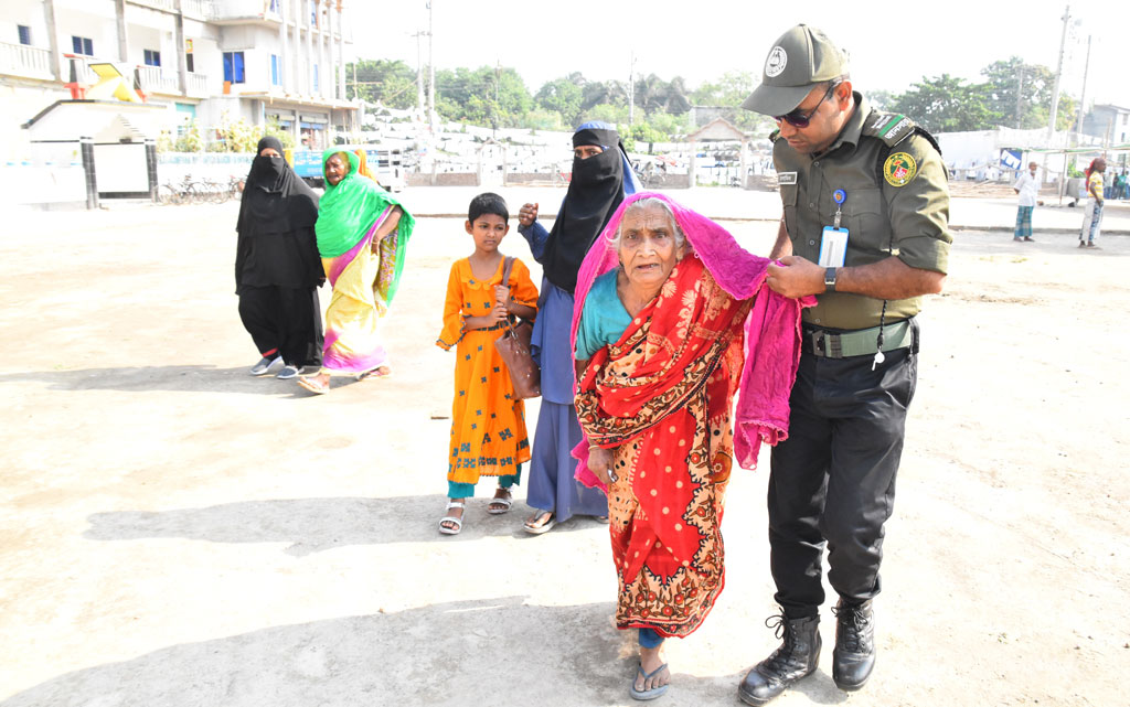 প্রচণ্ড গরম উপেক্ষা করে কাটাখালী পৌরসভার উপনির্বাচনে ভোট দিতে এসেছেন এক বৃদ্ধা। তাঁকে সহায়তা করতে দেখা যাচ্ছে এক আনসার সদস্যকে। কাটাখালীর জামিয়া উসমানিয়া হোছাইনাবাদ ভোটকেন্দ্র, রাজশাহী, ২৮ এপ্রিল ২০২৪। ছবি: মিলন শেখ