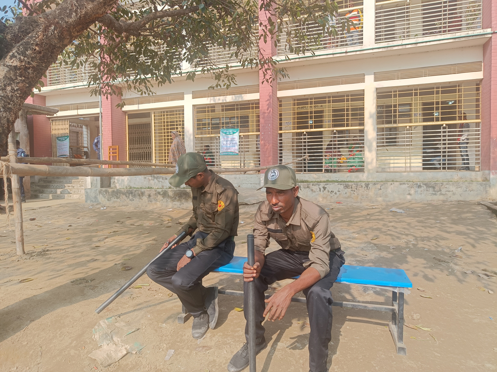 মাওনা ইউনিয়নের সিংগারদিঘী উচ্চ বিদ্যালয় কেন্দ্রে রোদ পোহাচ্ছেন আনসার সদস্যরা। ছবি: আজকের পত্রিকা