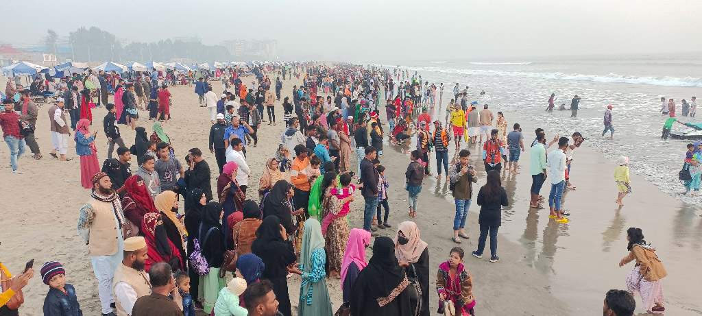 পরিবার পরিজন নিয়ে সমুদ্রসৈকতে সূর্যাস্ত দেখছেন পর্যটকেরা। সুগন্ধা পয়েন্ট, কক্সবাজার। ছবি: মাইনউদ্দিন শাহেদ