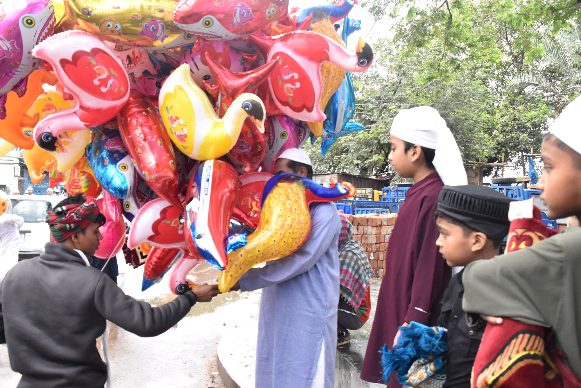 ঈদের নামাজ শেষে রঙিন বেলুন কিনছে শিশু-কিশোরেরা। আজ রাজশাহী নগরীর দরগাপাড়া এলাকা থেকে তোলা। ছবি: মিলন শেখ