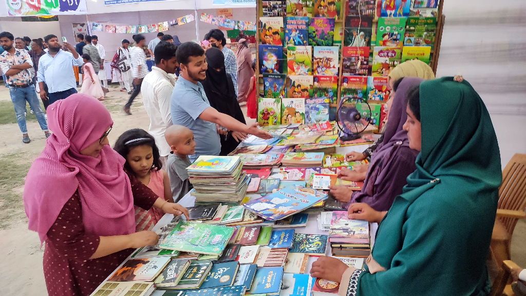 পাবনায় শুরু হয়েছে আট দিনব্যাপী বইমেলা। শহরের স্বাধীনতা চত্বরে বই দেখছেন পাঠকেরা। আজ শুক্রবার বিকেলে তোলা। ছবি: শাহীন রহমান