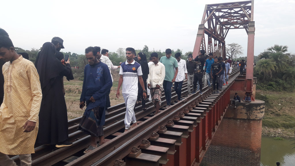 আক্কেলপুর উপজেলার সোনামুখী ইউনিয়নে তুলসীগঙ্গা নদীর ওপর হলহলিয়া রেল সেতুতে জীবনের ঝুঁকি নিয়ে পারাপার করছেন স্থানীয়রা। আক্কেলপুর, জয়পুরহাট, ২৪ এপ্রিল ২০২৩। ছবি: নিয়াজ মোরশেদ