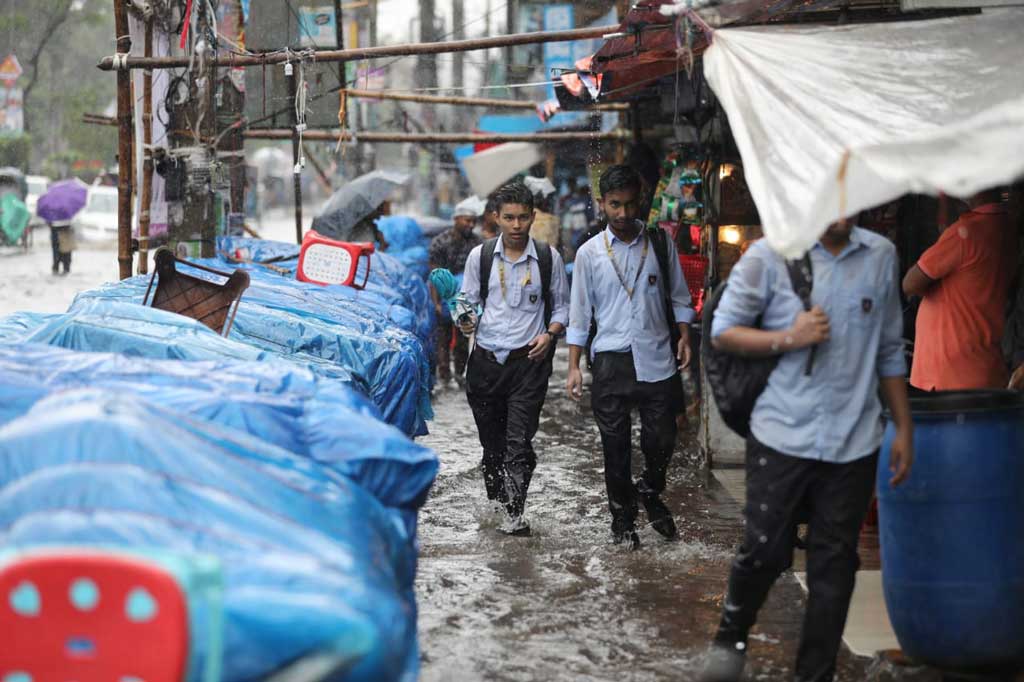 ঘূর্ণিঝড় রিমালের প্রভাবে ভোর থেকেই রাজধানী ঢাকায় শুরু হয়েছে বৃষ্টি। এর মধ্যেই ভিজে স্কুলে যেতে দেখা যাচ্ছে কয়েকজন শিক্ষার্থীকে। রাজধানীর ধানমন্ডি হকার্স মার্কেটের সামনে, ঢাকা, ২৭ মে ২০২৪ । ছবি: জাহিদুল ইসলাম