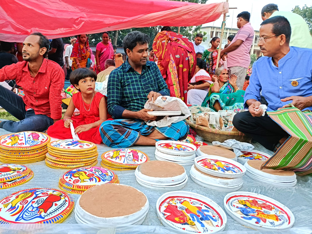 মেলায় মাটির তৈরি সুদৃশ্য নানা নিত্য ব্যবহার্য জিনিসপত্রের পসরা সাজিয়ে বসেছেন এক বিক্রেতা। ঘিওরের ডি এন পাইলট উচ্চ বিদ্যালয়ের মাঠে বিজয়া দশমীর মেলা, মানিকগঞ্জ, ২৫ অক্টোবর ২০২৩। ছবি: আব্দুর রাজ্জাক