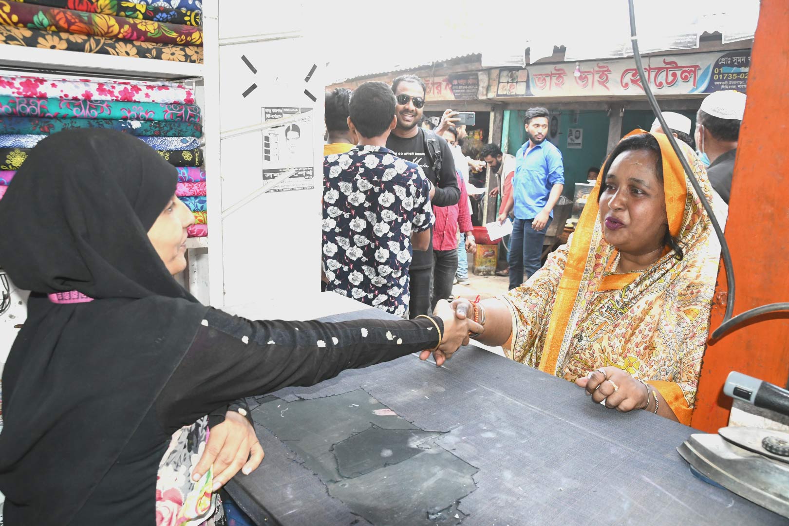 নির্বাচনী প্রচারণার অংশ হিসেবে একটি টেইলার্সে এক নারীর সঙ্গে করমর্দন করছেন সেলিনা হায়াৎ আইভী।