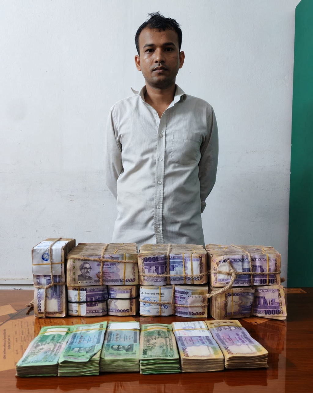 ৭৪ লাখ টাকাসহ গ্রেপ্তার কেয়ারটেকার মো. উজ্জ্বল। ছবি: সংগৃহীত