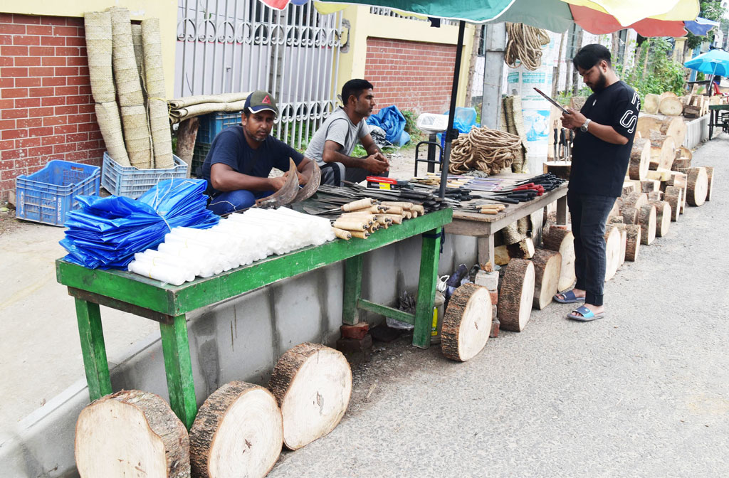 রাজশাহীতে ফুটপাতে বসেছে কোরবানির ঈদে পশু জবাইয়ের জন্য চাকু, ছুরি, কাঠের গুঁড়ি, পাটি, পলিথিনসহ বিভিন্ন জিনিসপত্রের দোকান। শেষ সময়ে এসে প্রয়োজনীয় সরঞ্জাম কিনছে নগরীর সাধারণ মানুষ। একেকটি কাঠের গুঁড়ি বিক্রি হচ্ছে ২০০ থেকে ১ হাজার পর্যন্ত। শালবাগান, রাজশাহী, ২৭ জুন ২০২৩। ছবি: মিলন শেখ।