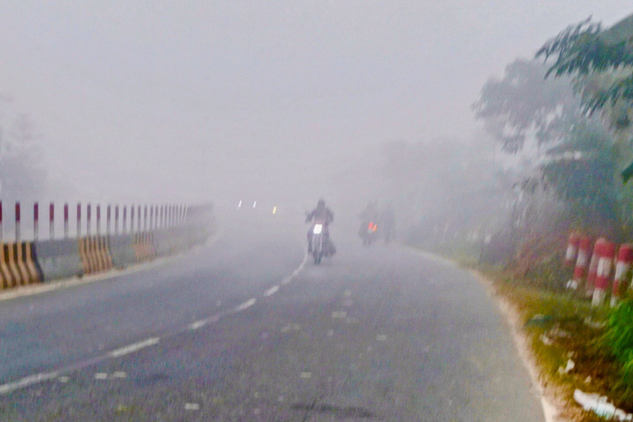 পৌষের ঘন কুয়াশায় ঢাকা পড়েছে মহাসড়ক। হেডলাইট জ্বালিয়ে ধীরগতিতে চলছে বাস, কার ও মোটরসাইকেল। মাথায় ঝুড়ি নিয়ে বাজারের পথে চলছেন শ্রমজীবী মানুষ। আজ সকালে ঢাকা-আরিচা মহাসড়কের মানিকগঞ্জের বানিয়াজুরী বাসস্ট্যান্ড এলাকা থেকে তোলা। ছবি: আব্দুর রাজ্জাক