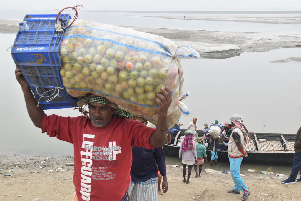 শীতের সকালে পদ্মা নদীর চর মাজারদিয়া গ্রাম থেকে নৌকায় করে নিয়ে আসা হচ্ছে কাঁচা-পাকা টমেটো। এরপর নৌকা থেকে নামিয়ে শ্রমিকেরা ভ্যানে করে বিক্রির জন্য নিয়ে যাচ্ছেন রাজশাহীর কোর্টবাজারে। আজ সোমবার সকালে রাজশাহী হাইটেক পার্ক এলাকায় পদ্মা নদীর ধারে। ছবি: মিলন শেখ