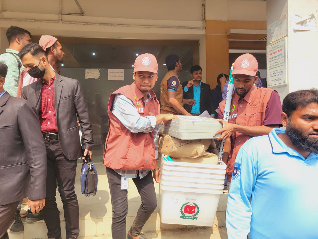 ভোট শুরুর আগে বিভিন্ন কেন্দ্রে সরঞ্জামাদি নিয়ে যাচ্ছেন কর্মকর্তারা। নরসিংদীর রায়পুরা হলরুমের সামনে থেকে আজ সকালে তোলা। ছবি: হারুনূর রশিদ