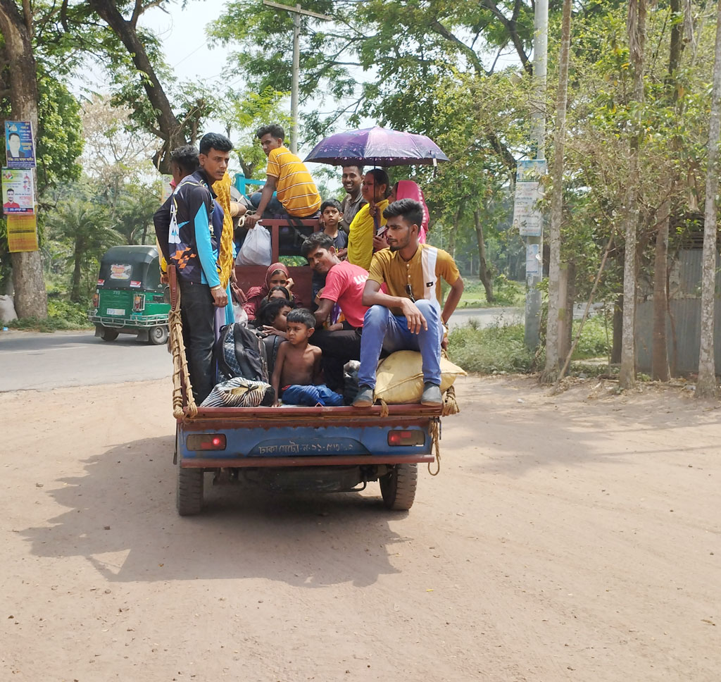 ঈদ উদ্‌যাপন করার জন্য ঢাকা থেকে পিকআপে করে বাড়ি ফিরছেন ঘরমুখো মানুষ। আজ মঙ্গলবার দুপুরে চাটমোহর উপজেলার মথুরাপুর ইউনিয়নের একটি তেল পাম্পের সামনে থেকে তোলা, পাবনা। ছবি: শুভাশীষ ভট্টাচার্য্য তুষার