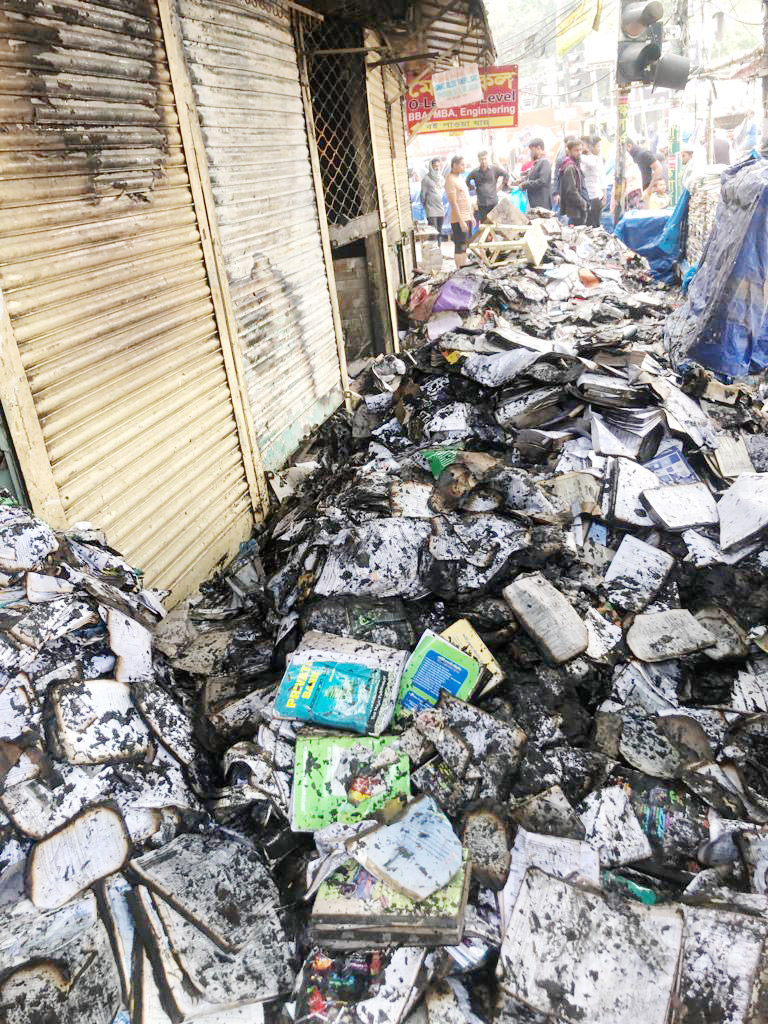 আগুনে পুড়ে যাওয়া বইয়ের স্তূপ। আগুন নেভাতে গিয়ে পানিতে অনেক বই নষ্ট হয়ে গেছে 
