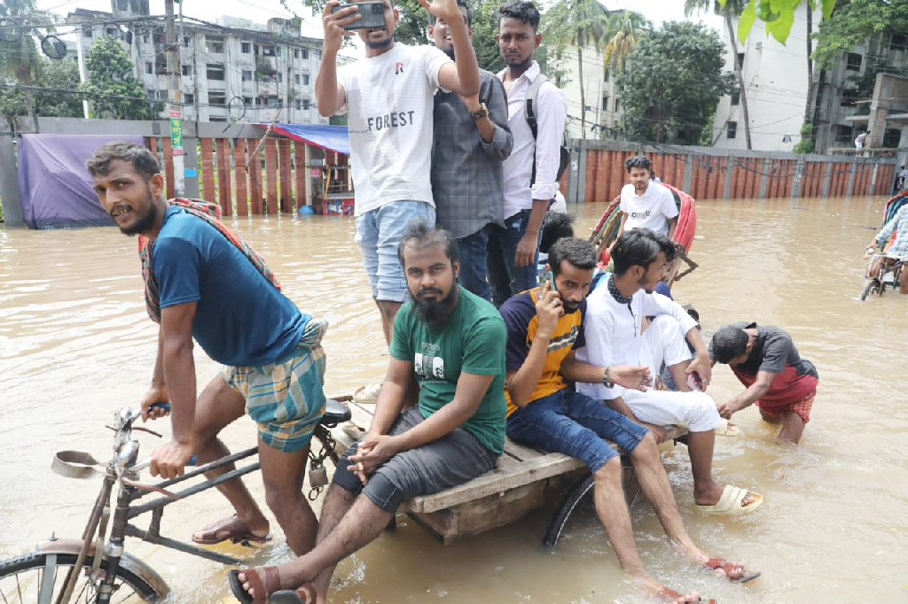 পায়ে হেঁটে গন্তব্যে পৌঁছানোর সুযোগ নেই। রিকশা পাওয়াও মুশকিল। তাই বাধ্য হয়ে এক ভ্যান গাড়িতে গাদাগাদি করে যাচ্ছেন কয়েকজন।