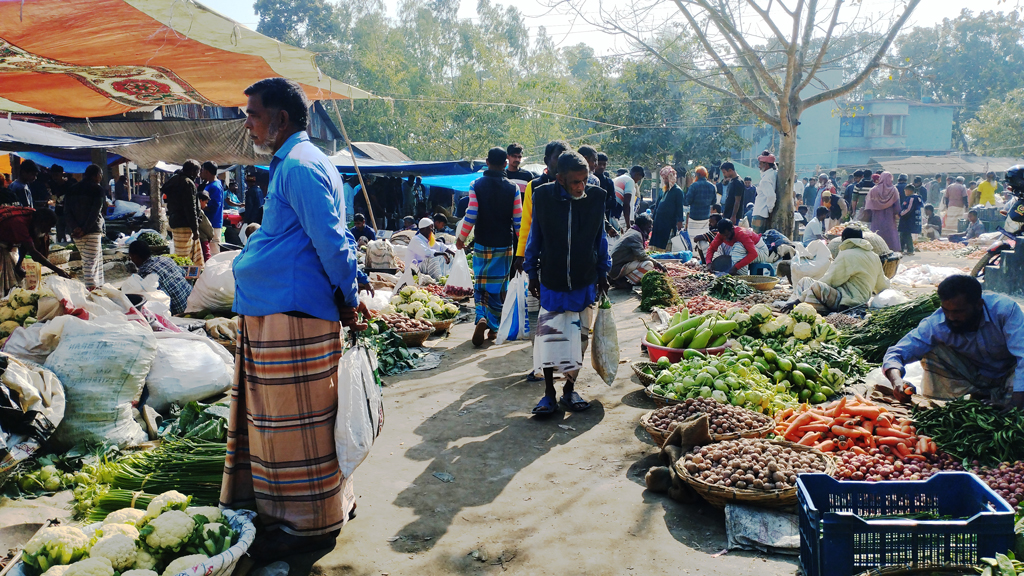 হাটে আলু, টমেটো, বেগুন, মিষ্টিকুমড়াসহ বিভিন্ন শীতকালীন শাকসবজি কেনাবেচায় ব্যস্ত ক্রেতা-বিক্রেতা। পাবনার চাটমোহর উপজেলার অমৃতকুন্ডা হাট এটি। প্রতি সপ্তাহের রোববার এই হাট বসে। উপজেলার বিভিন্ন এলাকা থেকে লোকজন এখানে কেনাকাটা করতে আসেন। আজ রোববার দুপুরে তোলা। ছবি: শুভাশীষ ভট্টাচার্য্য তুষার