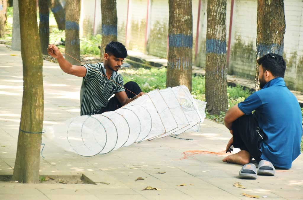 পদ্মার পানি বাড়তে থাকায় রাজশাহীর শ্রীরামপুরে গাছতলায় বসে জাল মেরামতে ব্যস্ত জেলেরা। নতুন জাল কিনছেন আর পুরাতন জাল ঠিক করছেন মাছ ধরার প্রস্তুতিতে। ছবি: মিলন শেখ
