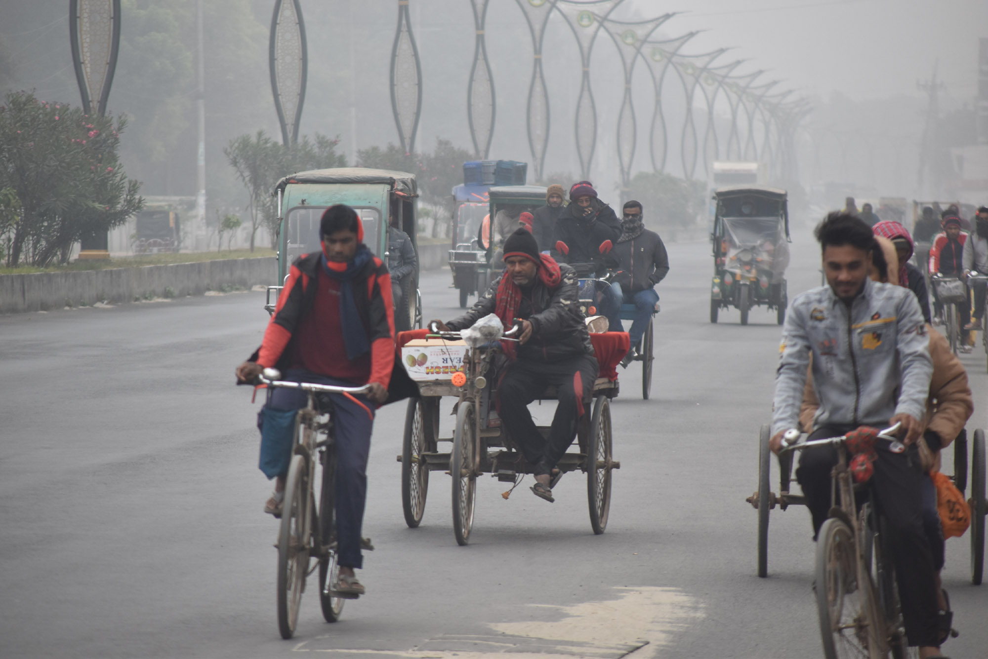 ঘন কুয়াশায় ঢাকা পড়েছে রাজশাহী শহর। শীতের মধ্যে গরম পোশাক পরে কাজে যেতে রাস্তায় বের হয়েছে লোকজন। কিছু যানবাহন সকালে হেডলাইট জ্বালিয়ে চলাচল করে। আজ সকাল সাড়ে ৯টায় বিনোদপুর এলাকা থেকে তোলা। ছবি: মিলন শেখ