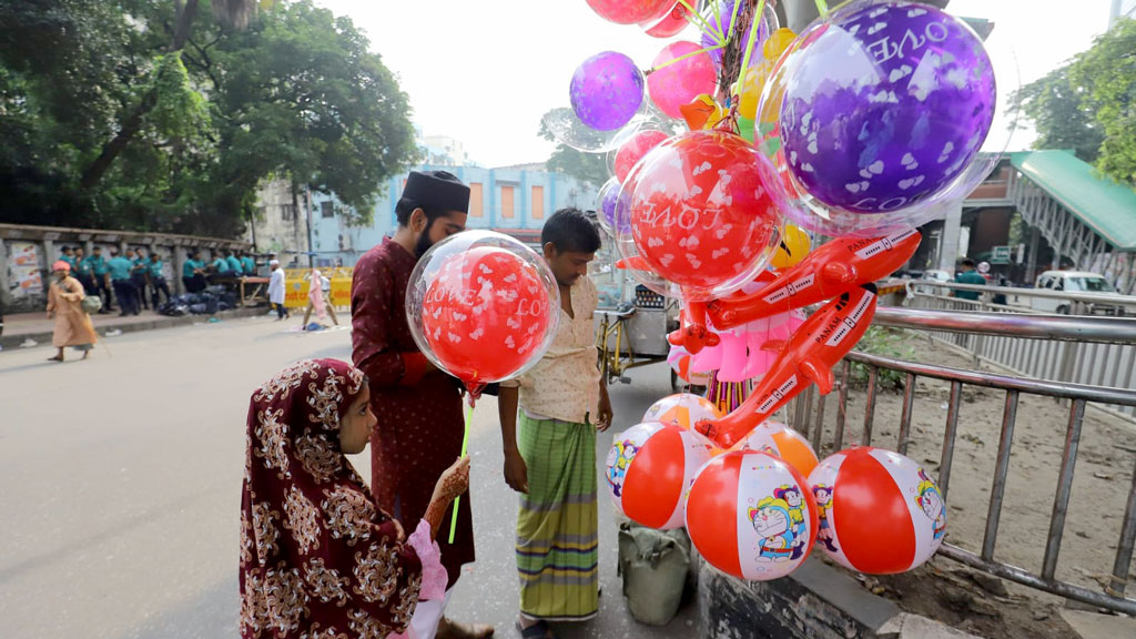 ঈদের নামাজ শেষে শিশুদের নানা রকম আবদার পূরণ করেন বড়রা। ছবি: আজকের পত্রিকা