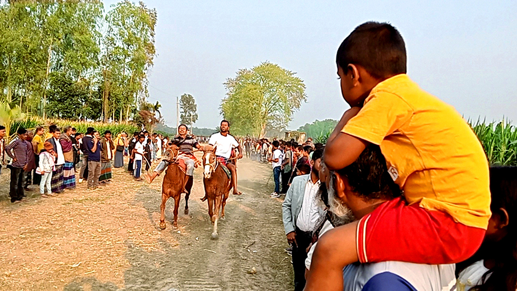 বাংলাদেশের শত বছরের পুরোনো ঐতিহ্য গ্রামীণ মেলা। মেলার প্রধান আকর্ষণ ঘোড়দৌড় দেখতে দাদার কাঁধে চড়ে মেলায় এসেছে পেঁচারকান্দা গ্রামের শিশু তালহা। ঘিওর, মানিকগঞ্জ, ৫ ফেব্রুয়ারি। ছবি: আব্দুর রাজ্জাক।