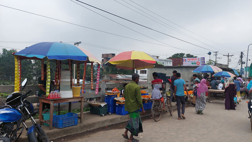 হোজা নদীর ওপর সেতুটির ফুটপাত এখন ভ্রাম্যমাণ ব্যবসায়ীদের অবৈধ দখলে। ছবি: আজকের পত্রিকা