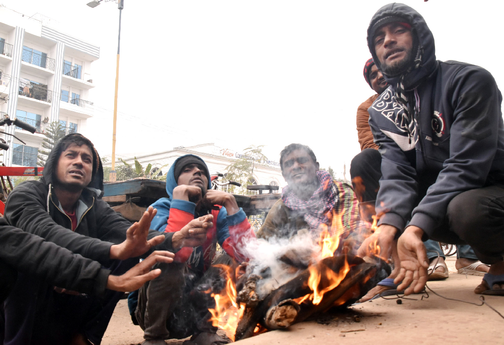 শীতের তীব্রতায় বিপর্যস্ত রাজশাহীর জনজীবন। দুপুর বেলায় কনকনে ঠান্ডায় রাস্তার পাশে আগুন জ্বালিয়ে তাপ পোহাচ্ছেন ভ্যানচালকেরা। নগরীর তেরখাদিয়া এলাকা থেকে তোলা। ছবি: মিলন শেখ