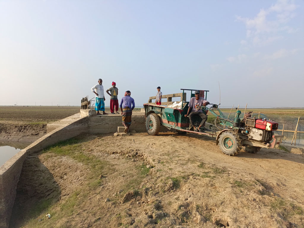 হাওরের মানুষের জীবন-সংগ্রামে নিত্যসঙ্গী দুর্ভোগ। বর্ষায় ব্রিজের দুই পাশের মাটি সরে গিয়ে সৃষ্টি হয়েছে বড় বড় গর্ত, বিচ্ছিন্ন হয়ে পড়েছে সড়ক। ফলে কৃষি উপকরণ গাড়িতে করে ব্রিজ পর্যন্ত নিয়ে সেখান থেকে মাথায় করে অন্য পাশের জমিতে নিতে হচ্ছে কৃষকদের। এতে দুর্ভোগে পড়েছেন হাজারো কৃষক, ব্যাহত হচ্ছে কৃষিকাজ। কিশোরগঞ্জের মিঠামইনের গোপদীঘির শরীফপুর হাওরের সাদ্দের বাঁধ এলাকা থেকে সম্প্রতি তোলা। ছবি: হারুনূর রশিদ
